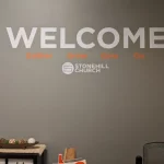 Welcome graphic on grey wall of church